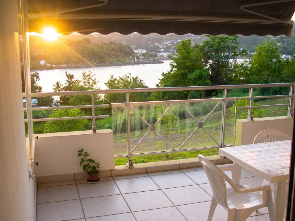 a balcony with a table and a view of a river at Appartement face à la mer à La Trinité – 70 m² – Terrasse in La Trinité