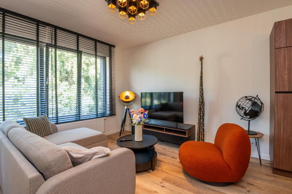 a living room with a couch and a chair at Beautiful and spacious renovated home for 10 in Ostend
