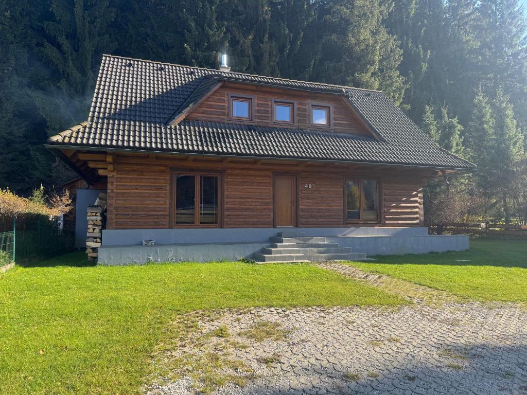 a small wooden house in a yard with a grass at Chalúpka pod lesom Zázrivá in Zázrivá