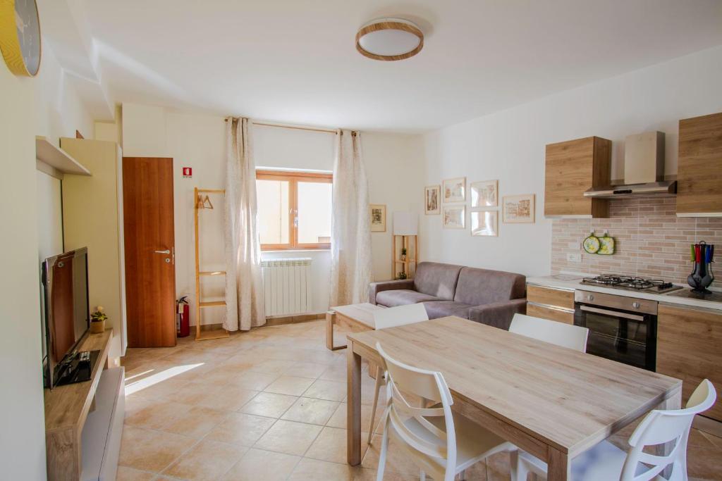 a kitchen and living room with a wooden table and chairs at La Ruetta in LʼAquila