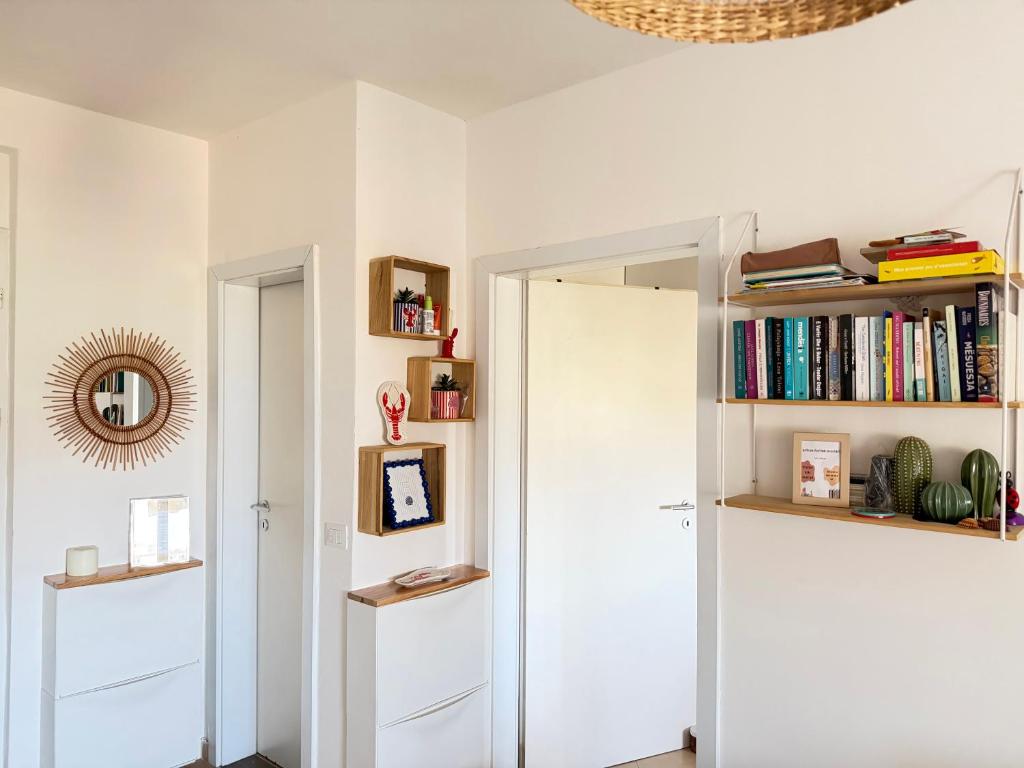 a hallway with a white door and bookshelves at The Flip-Flop Apartment in Shëngjin