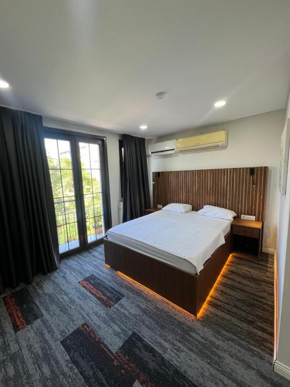 a bedroom with a large bed and large windows at Vicolo Moda Kadıköy in Istanbul