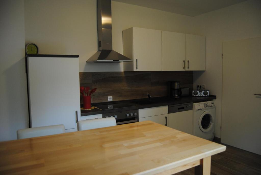 eine Küche mit einem Holztisch und einer Arbeitsplatte in der Unterkunft Ferienwohnung am Donnersberg in Dannenfels