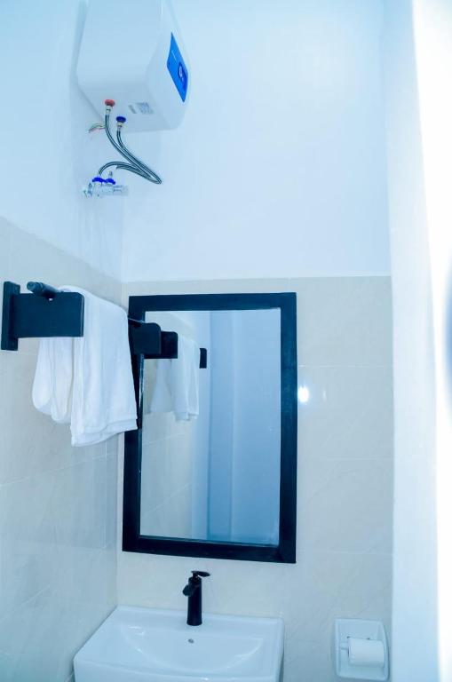 a bathroom with a mirror and a white sink at Ray Infinity Suites in Paje