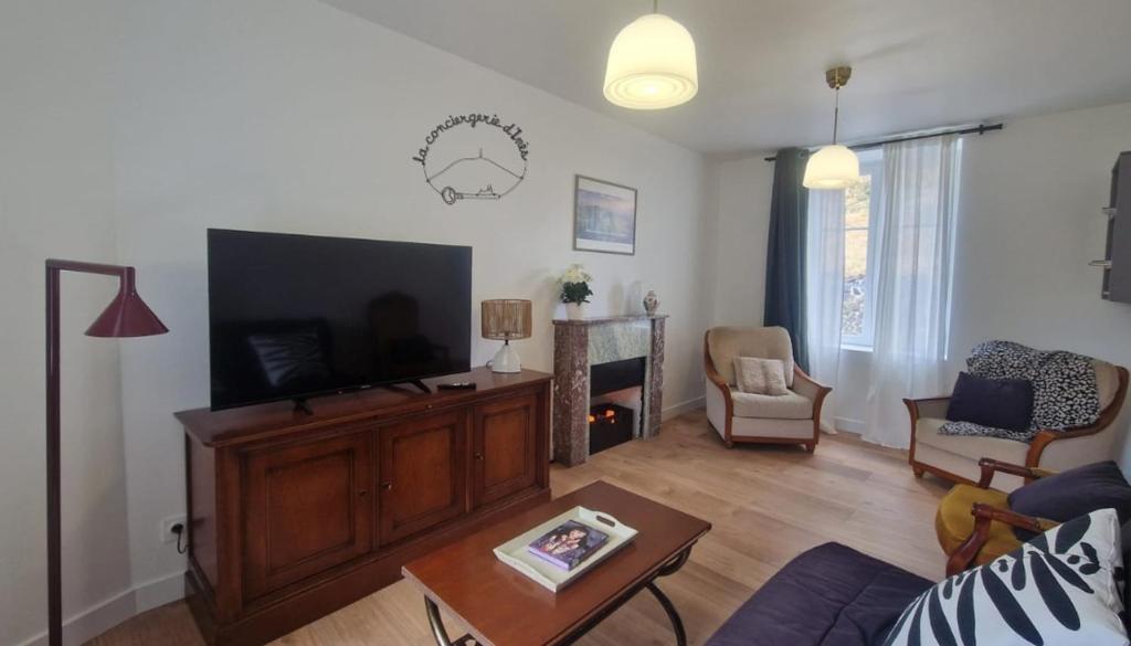 a living room with a flat screen tv on a entertainment center at Gite De Sandra #Confort in Olby