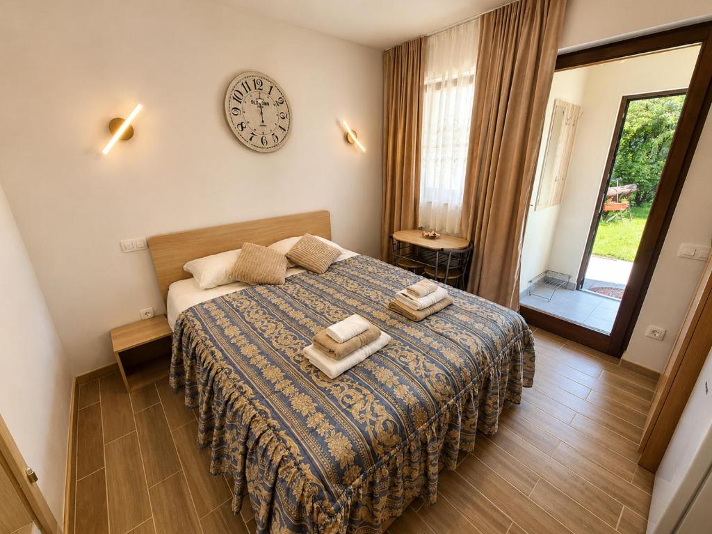a bedroom with a bed with a clock on the wall at Apartment Alee in Lesce