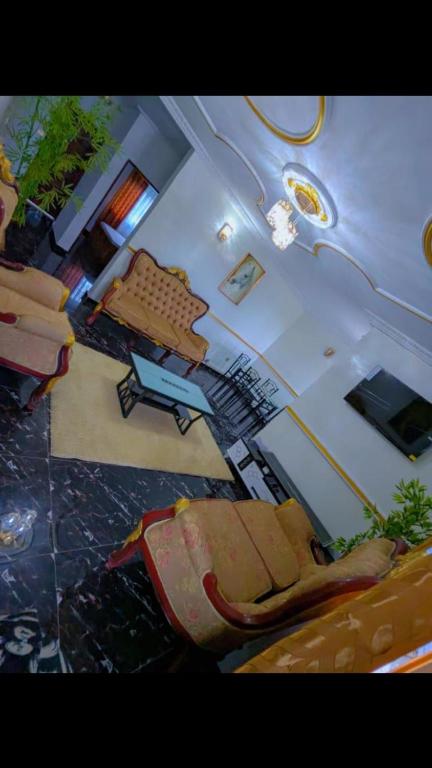 a view of a living room with a couch and a chair at Golden fortune Hotel apartment in Molyko