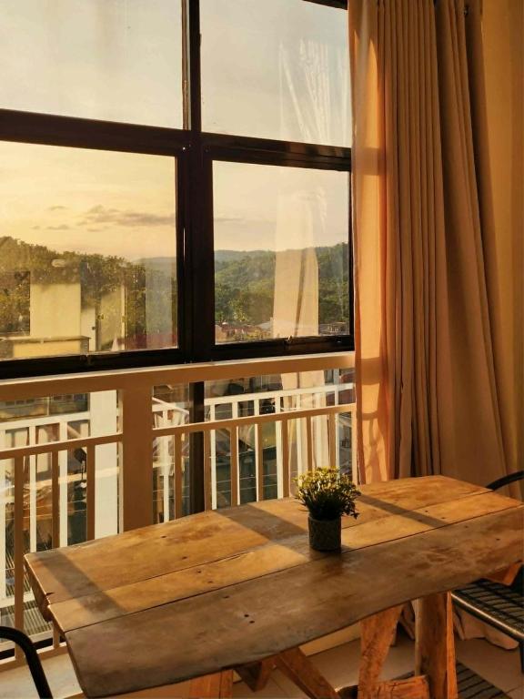 a wooden table in front of a large window at R Hotel Centro and Restaurant in Marinduque