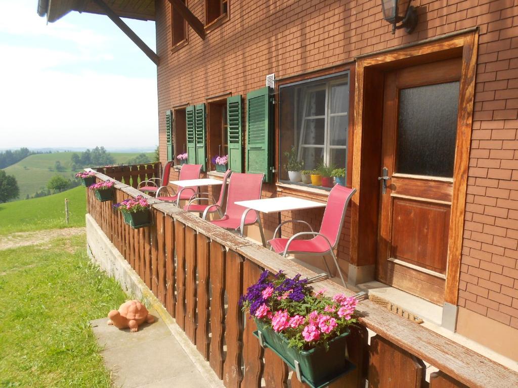 a balcony with pink chairs and tables on a house at Naturfreunde in Hergiswil