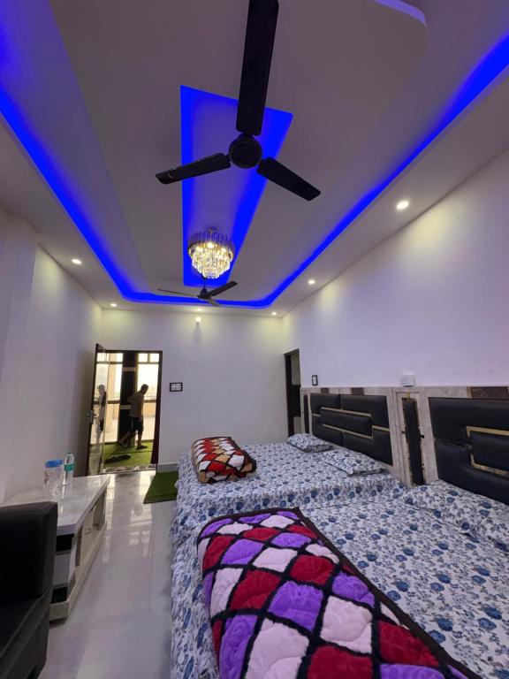 a bedroom with two beds and a ceiling fan at DANGWAL HoTEL in Srīnagar