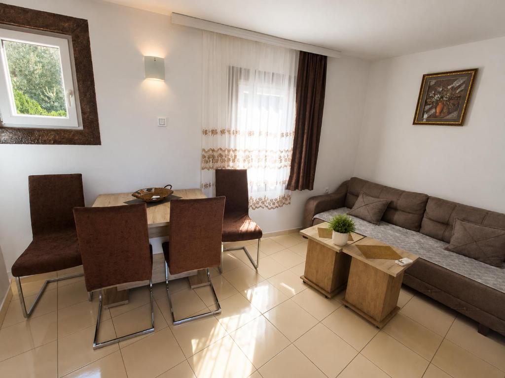 a living room with a couch and a table and chairs at Peace in Bečići