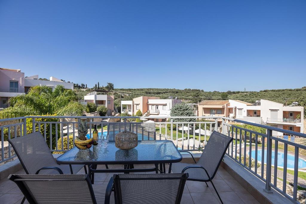 a patio with a table and chairs on a balcony at A&E Cretan Oasis in Loutra