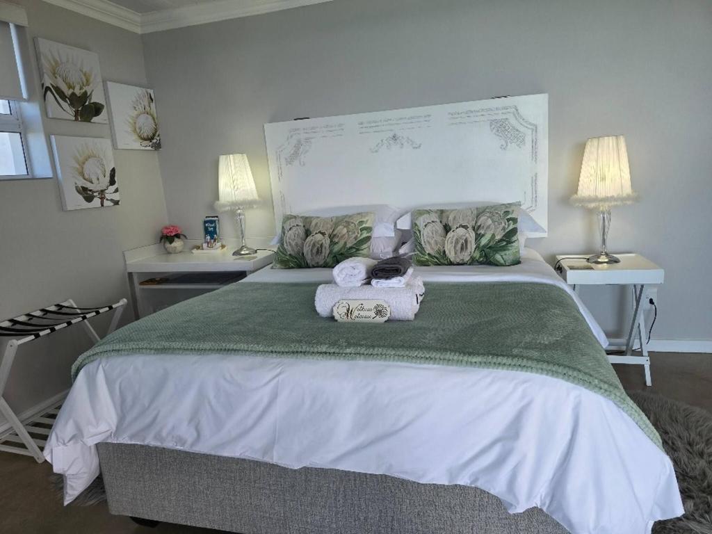 a bedroom with a large bed with towels on it at View on 42 - Protea Room - Small cozy room with ocean view in Mossel Bay