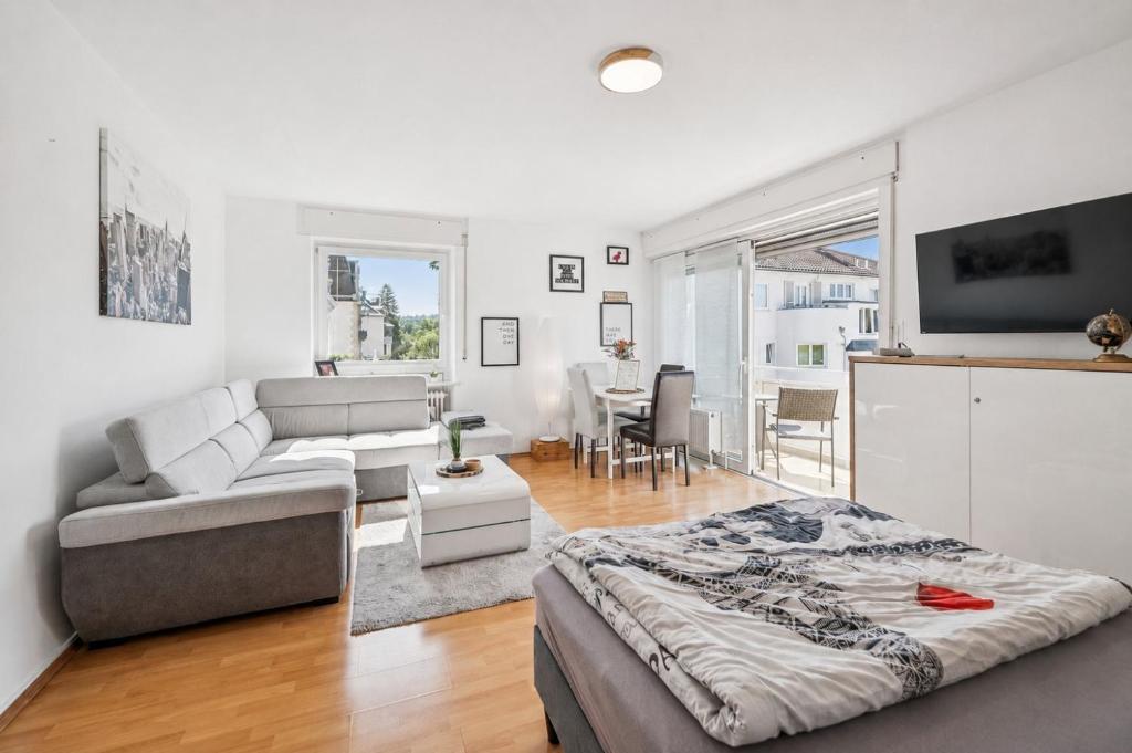 a white living room with a bed and a couch at Charmante Stadtwohnung im Zentrum in Wiesbaden