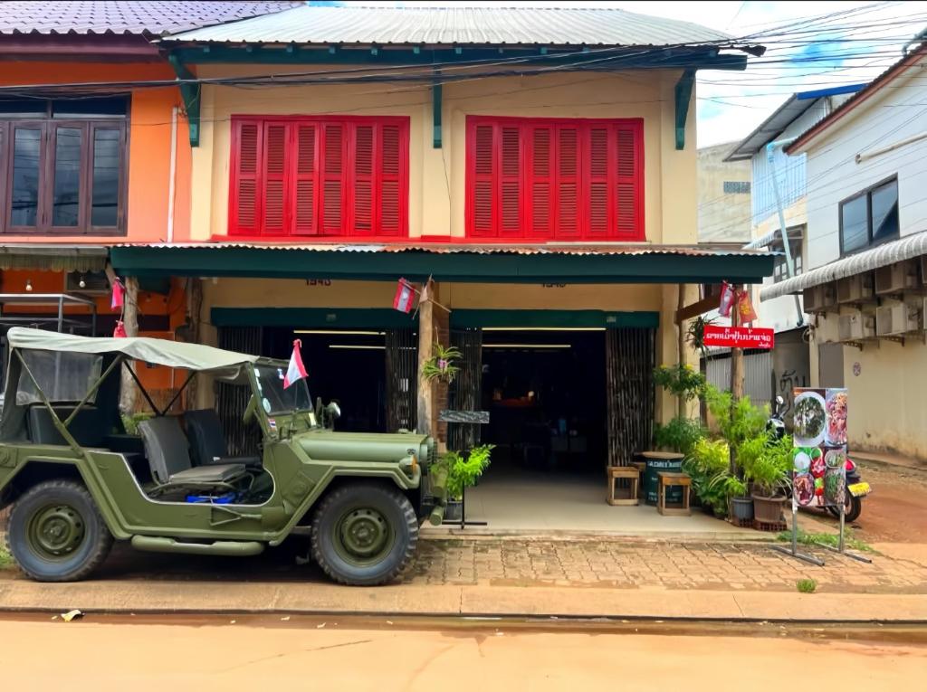 a green jeep parked in front of a building at Via Pakse Hostel & Cafe in Pakse