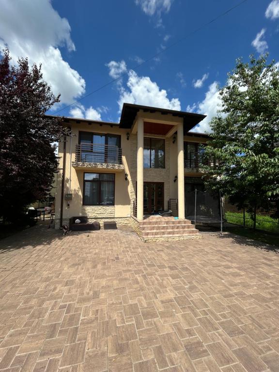 a house with a brick driveway in front of it at Vila La Cazemată Bucov in Satu Bucovei