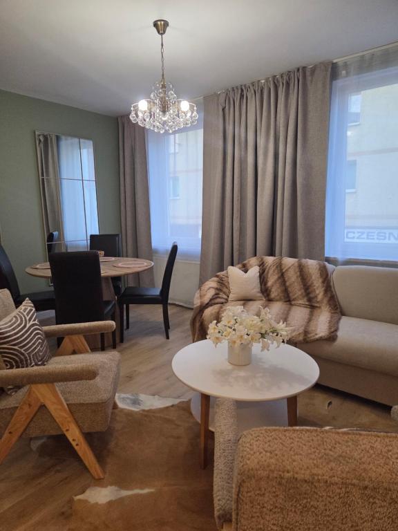 a living room with a couch and a table at Apartament Lipowa Centrum in Mrągowo