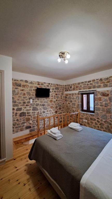 a bedroom with two beds in a room with brick walls at Stone house 2 in Líthion
