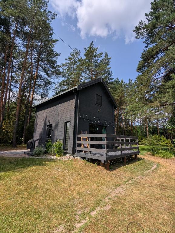 a black house in the middle of a field at Dom wakacyjny i Domki letniskowe nad Tanwią Roztocze in Narol