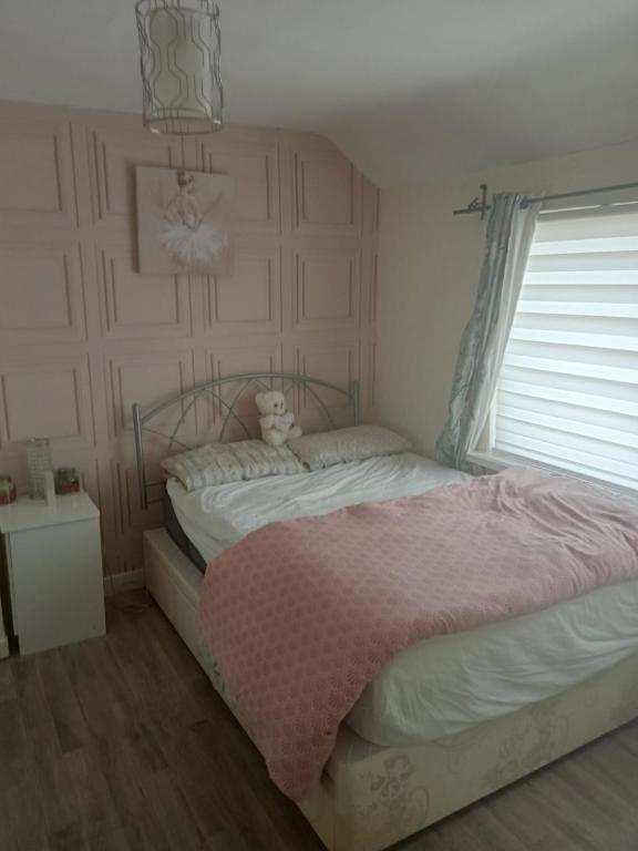 a bedroom with a bed with a teddy bear on it at Cozy stay in Dublin