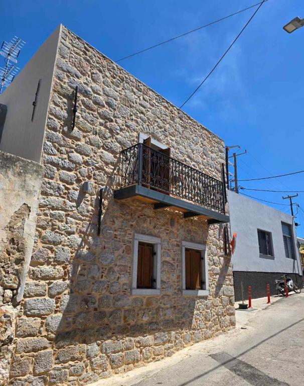 a stone building with a balcony on the side of it at Stone house 1 in Líthion