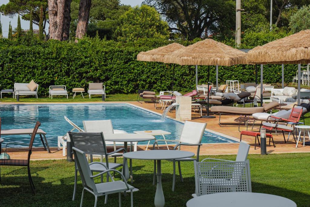 a pool with chairs and tables and umbrellas at Casale Incanto in Terracina
