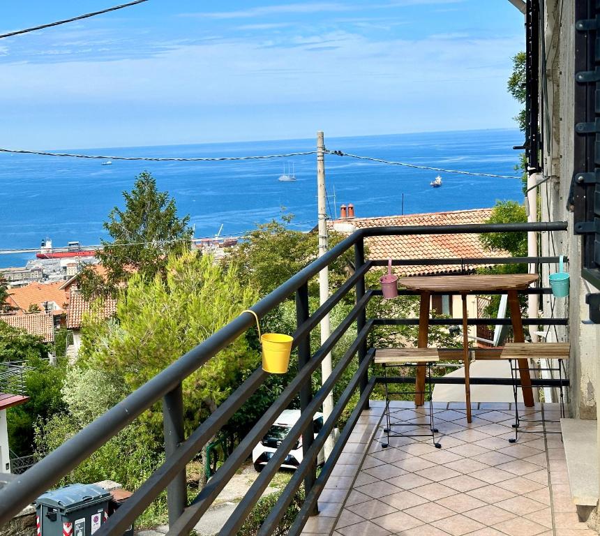 a balcony with a table and a view of the ocean at casa Ludovica-vista mare-giardino privato in Trieste