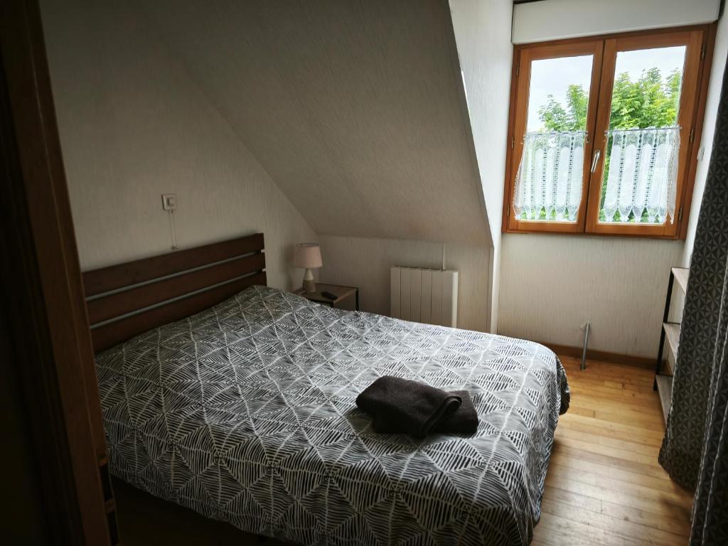 a bedroom with a bed with a black bag on it at Villa les ecluses in Le Crotoy