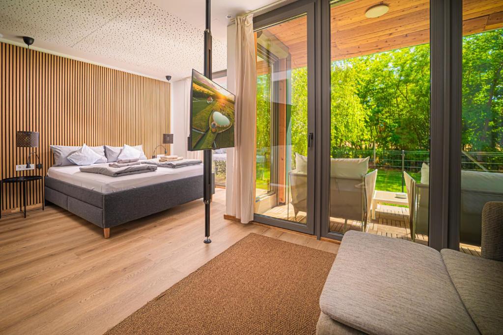a bedroom with a bed and a sliding glass door at Chalets Franciska Major, Pro Village in Sopronkövesd