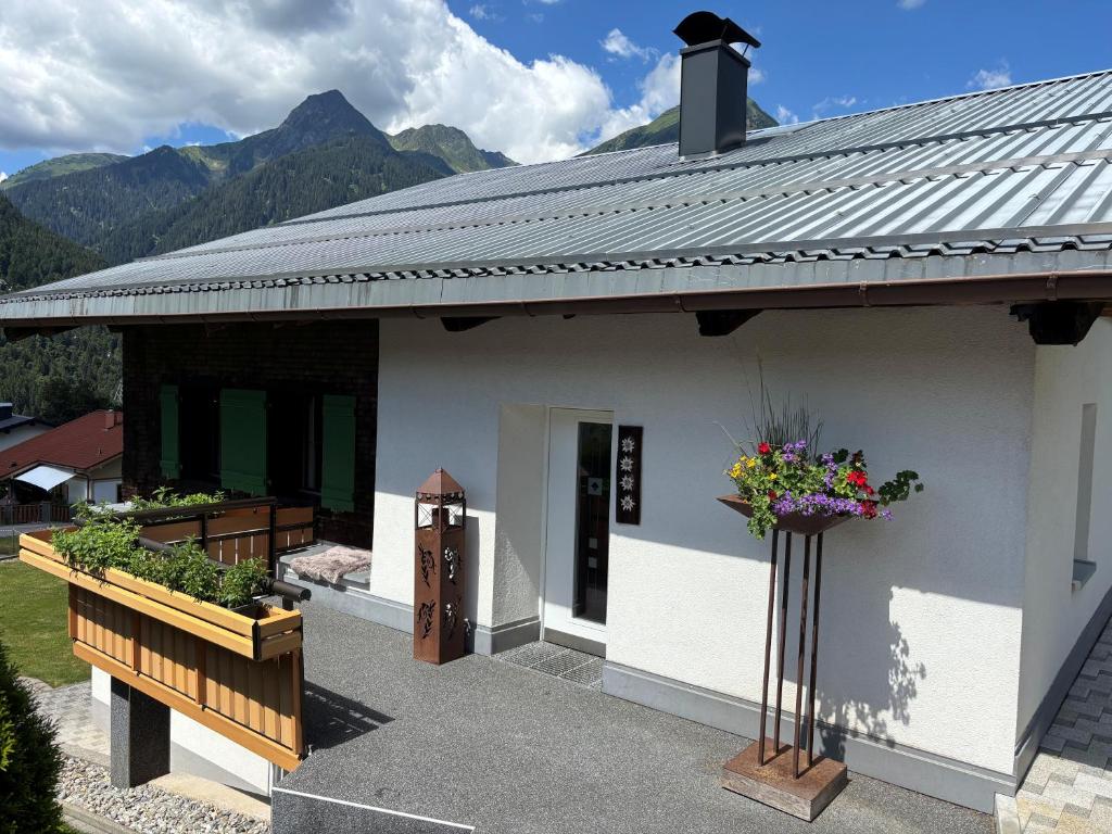 a white house with flowers on the side of it at Veronikas Chalet in Sankt Gallenkirch