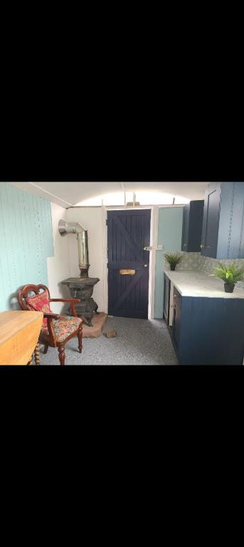 a kitchen with blue cabinets and a table and a chair at Rowan retreat,Renwick, Penrith,CA10 1LA in Penrith
