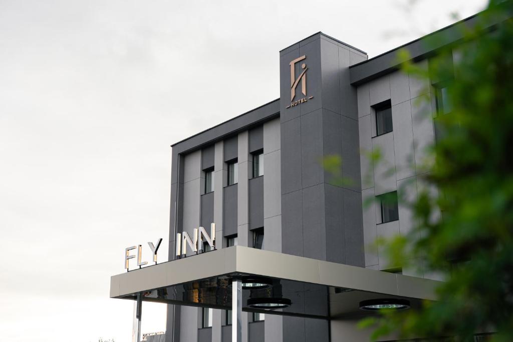 ein hohes Gebäude mit einer Uhr auf dem Dach in der Unterkunft Fly Inn Hotel in Vragolija