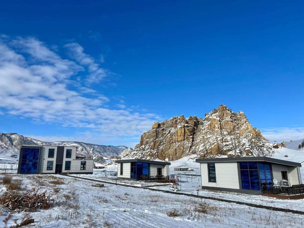 a group of buildings in front of a mountain at Royal Villa in Yoliin Hural
