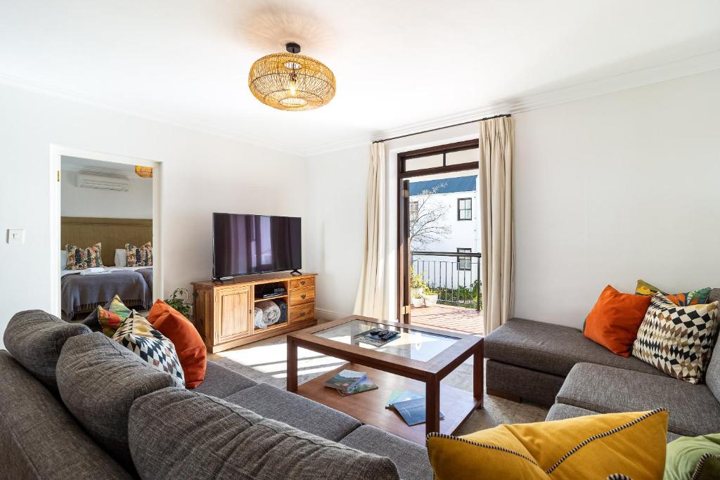 a living room with a couch and a tv at Winelands Golf Lodges 11 in Stellenbosch