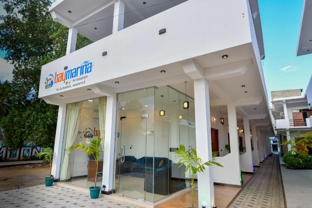 a building with glass doors and a sign on it at Bay Marina in Arugam Bay