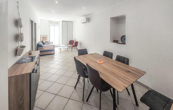 a dining room with a wooden table and chairs at Le Troyes à Sète in Sète