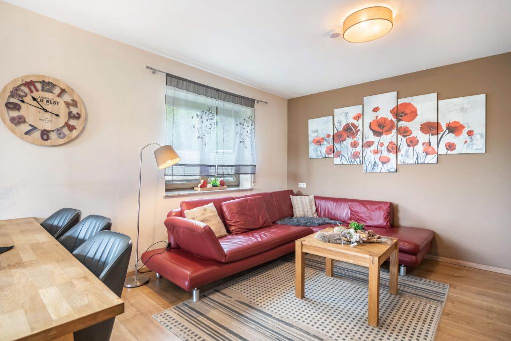 a living room with a red couch and a table at Eifel Dream Zingsheld in Fleringen