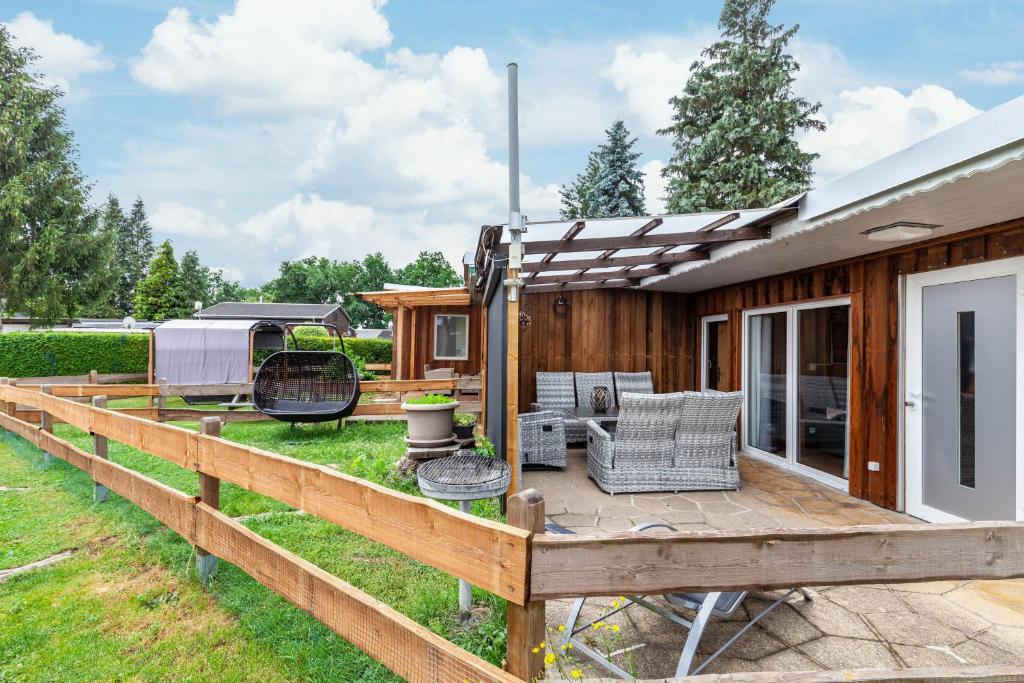 a wooden deck with chairs and a house at Ferienhaus 34 in Zadelsdorf