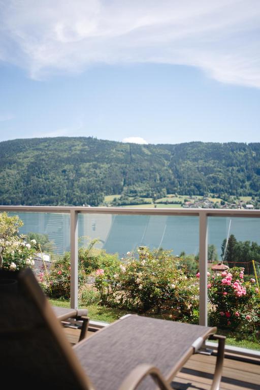 a balcony with a table and a view of the water at Hotel Ossiacher See in Stiegl