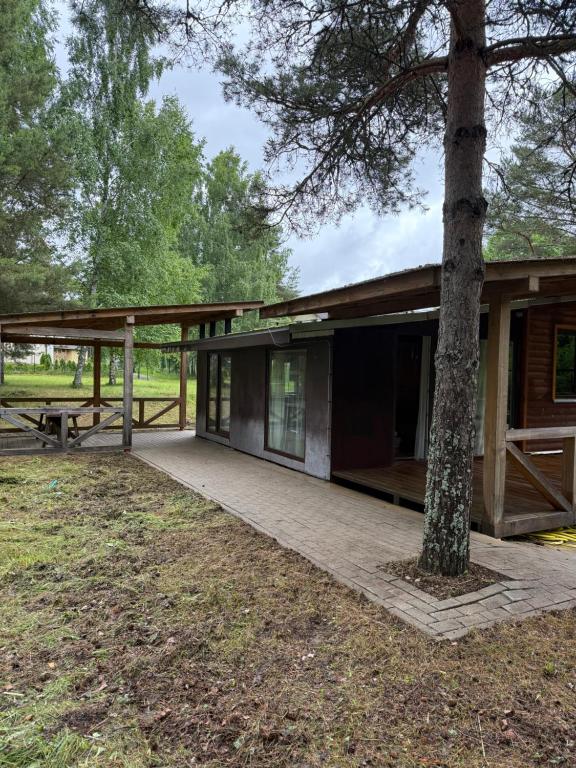 a building with a picnic table and a tree at Razna Lake House in Astici