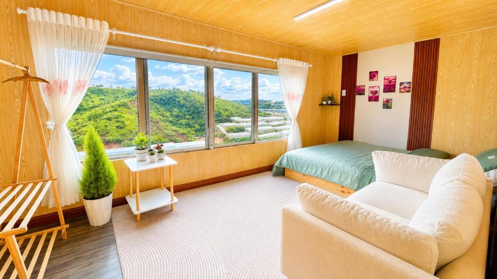 a living room with a couch and a bed and a window at LaLa Hill in Ấp Kim Thạch