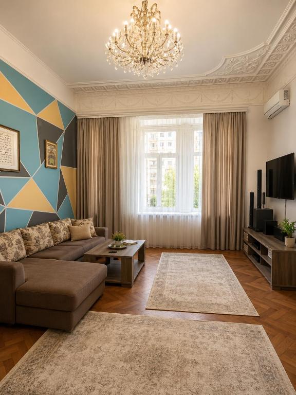 a living room with a couch and a chandelier at BakuDowntownHostel in Baku