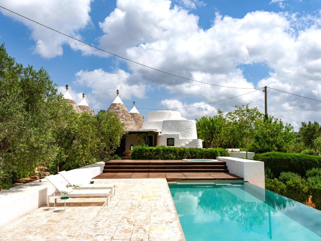 a villa with a swimming pool and a house at Cocotrullo in Ostuni
