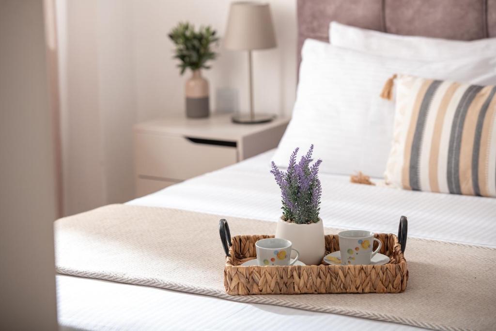 a tray with two cups and flowers on a bed at Silvia's Haus in Neos Marmaras