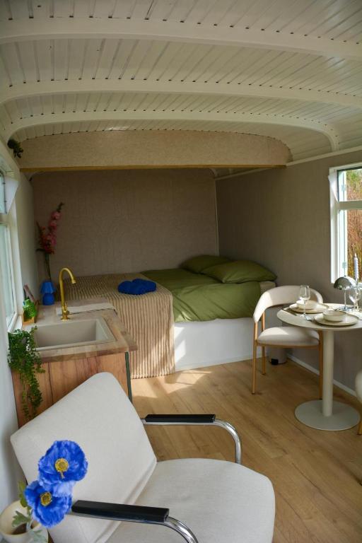 a room with a bed and a table and a sink at Bed & Bloemen in Niebert