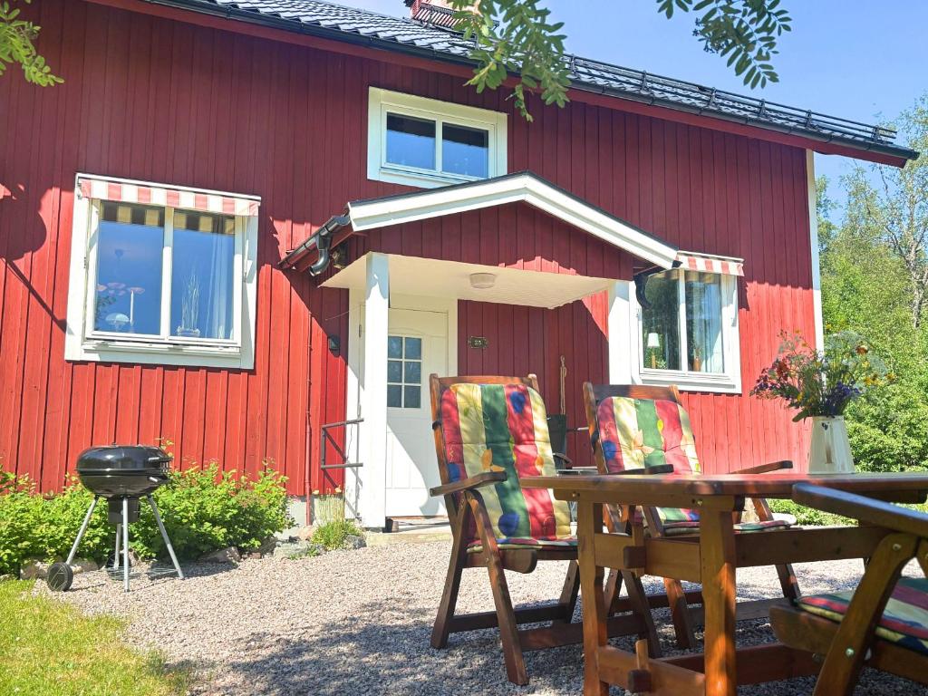 a red building with two chairs and a grill at Hus Fee in Fredriksberg