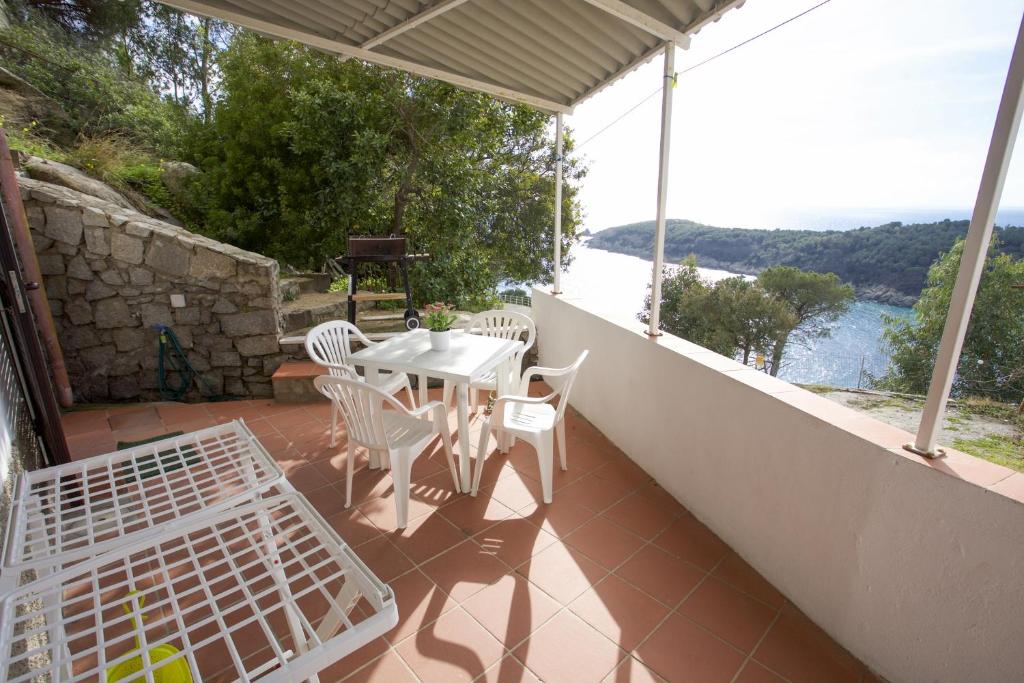 a patio with a table and chairs on a balcony at Costa Ovest - Goelba in Fetovaia