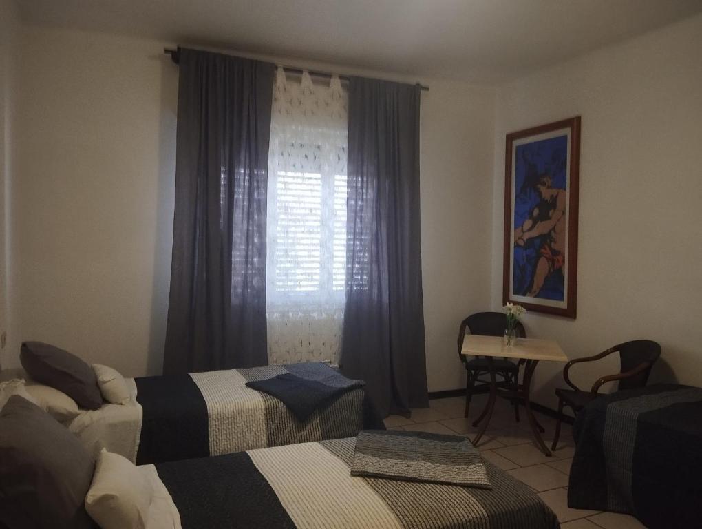 a hotel room with two beds and a window at Alice House in Arceto