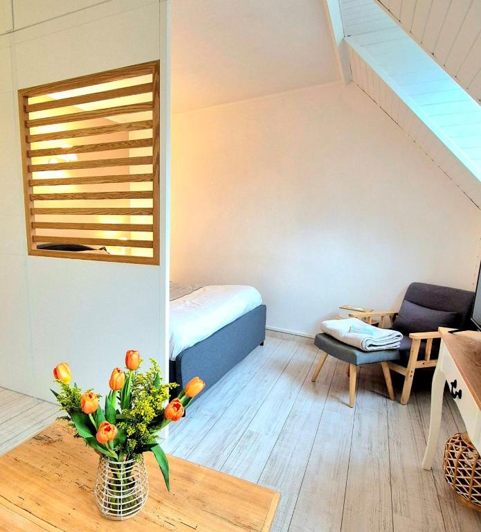 a small room with a bed and a vase of flowers at Centre Chartres Parking privé Climatiseur in Chartres