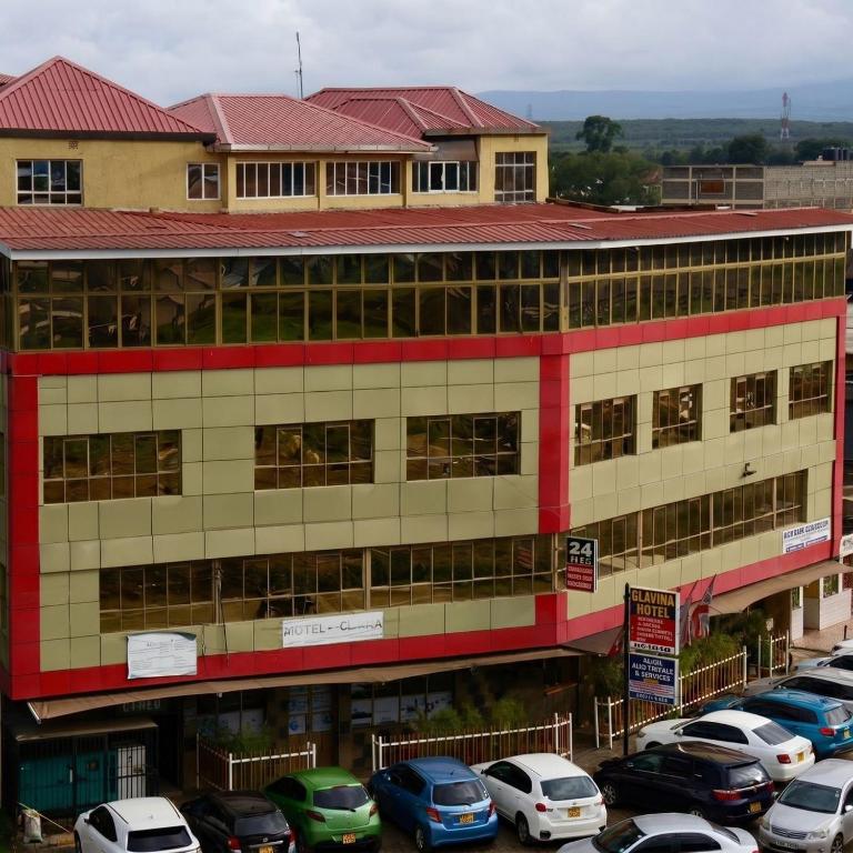 a large building with cars parked in a parking lot at Clavina Hotel in Gilgil